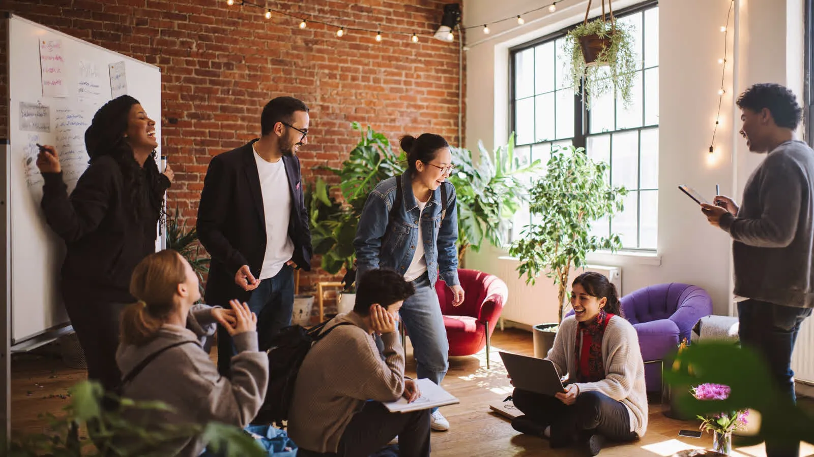 Founders and talent working through a plan together in a sunlit brick loft